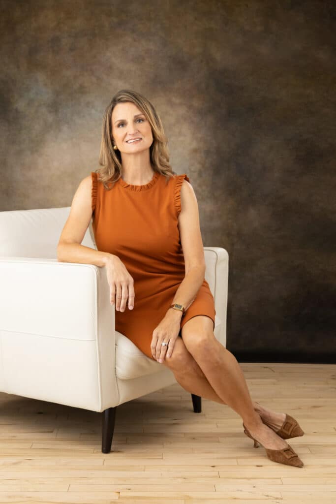 Woman business owner in white leather chair posing naturally for personal branding photography session