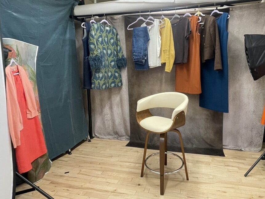 Wardrobe selections for a professional headshot experience ready on hangers in a photography studio